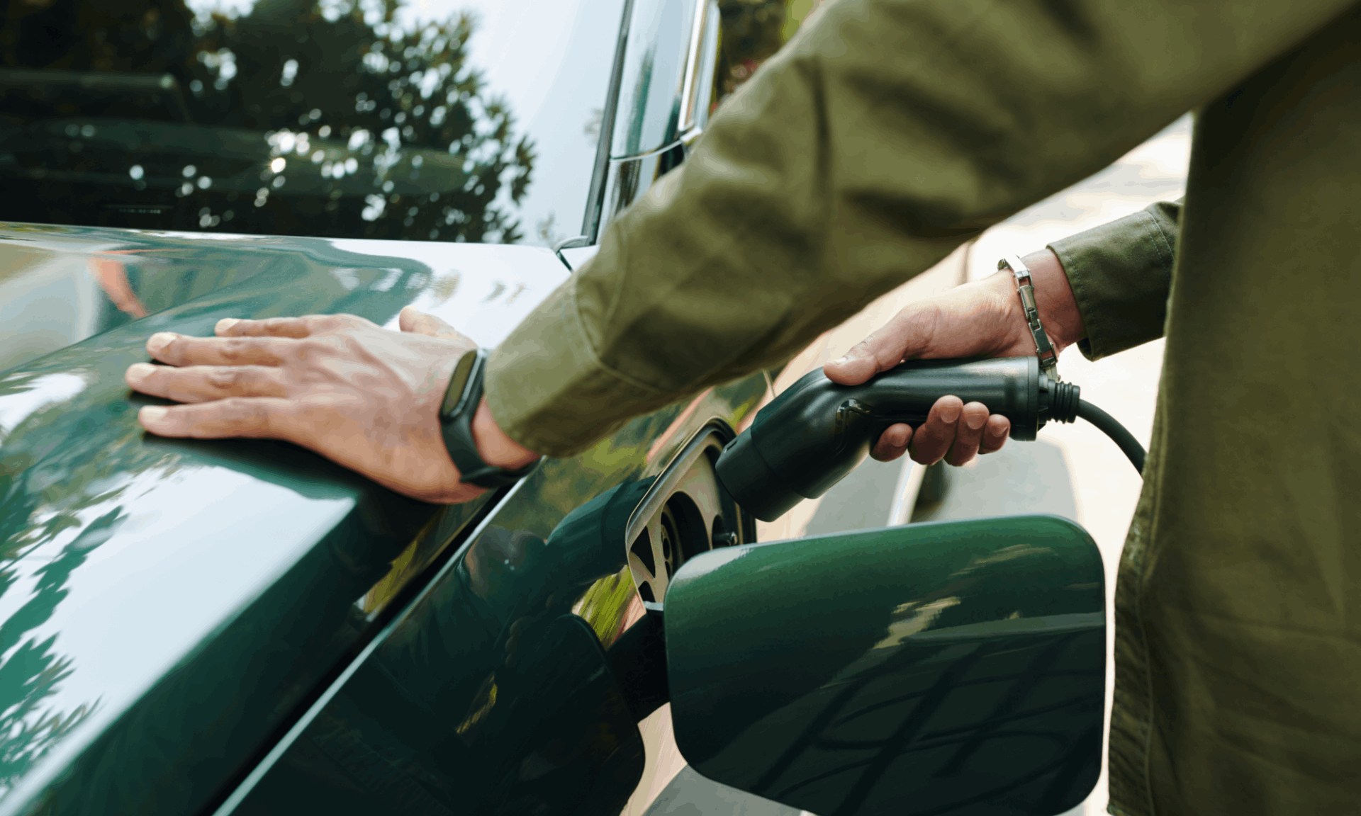man charging green electric car