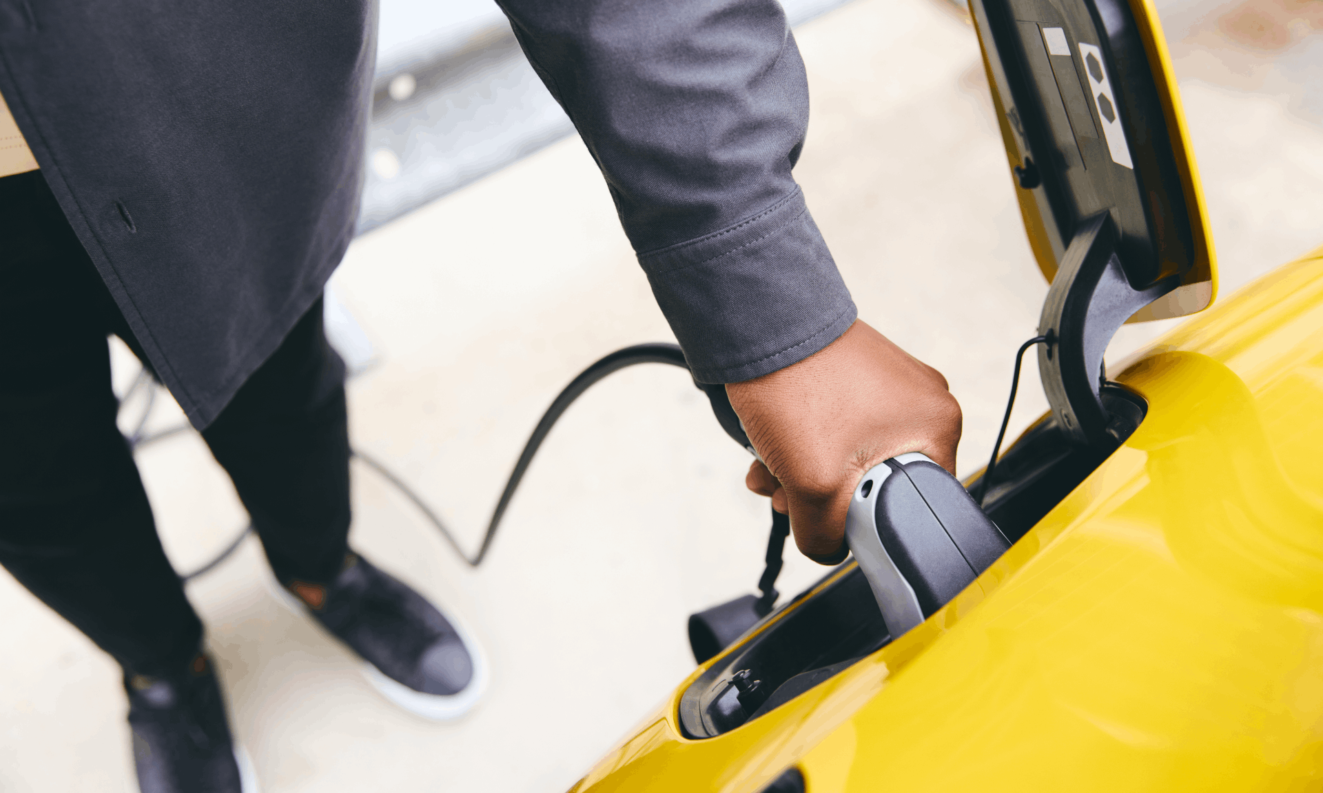 plugging in yellow electric car to charge