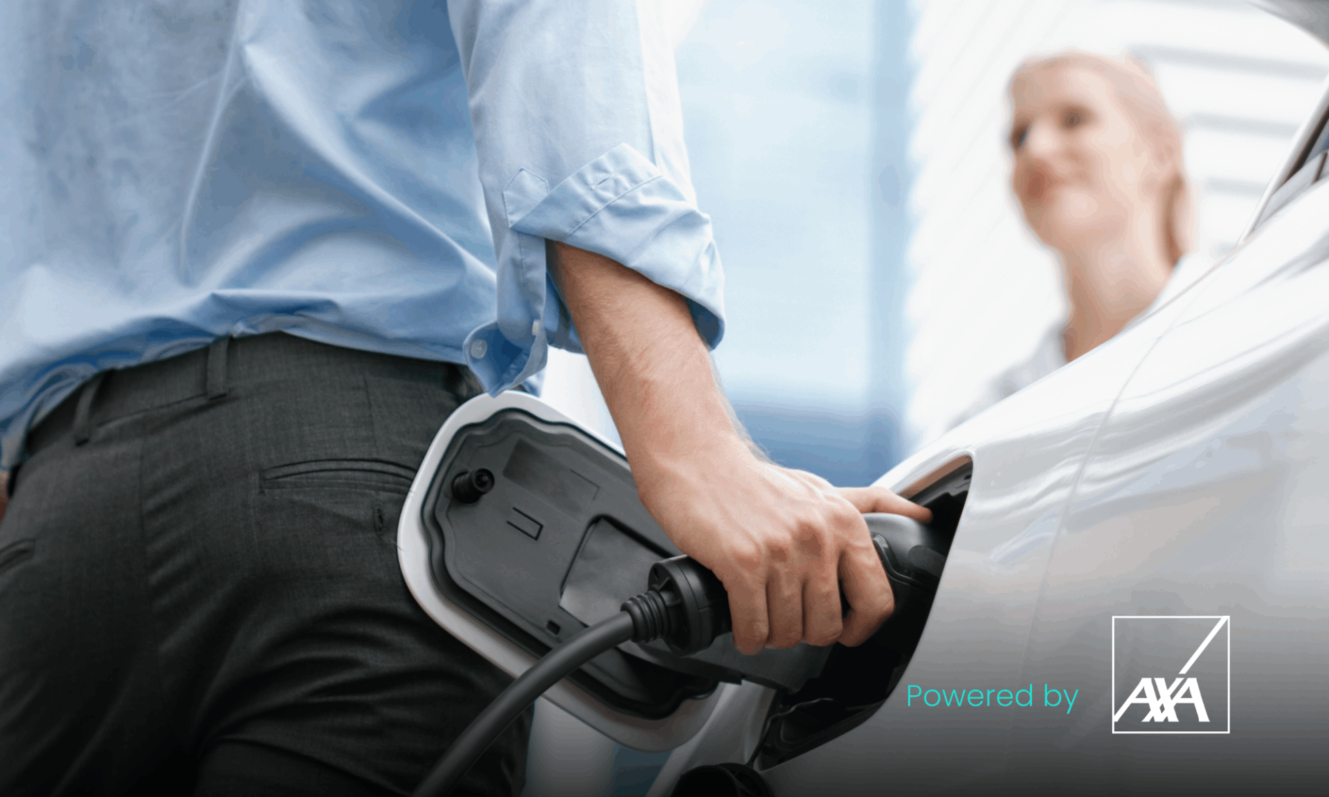 man in blue shirt plugging car in to charge