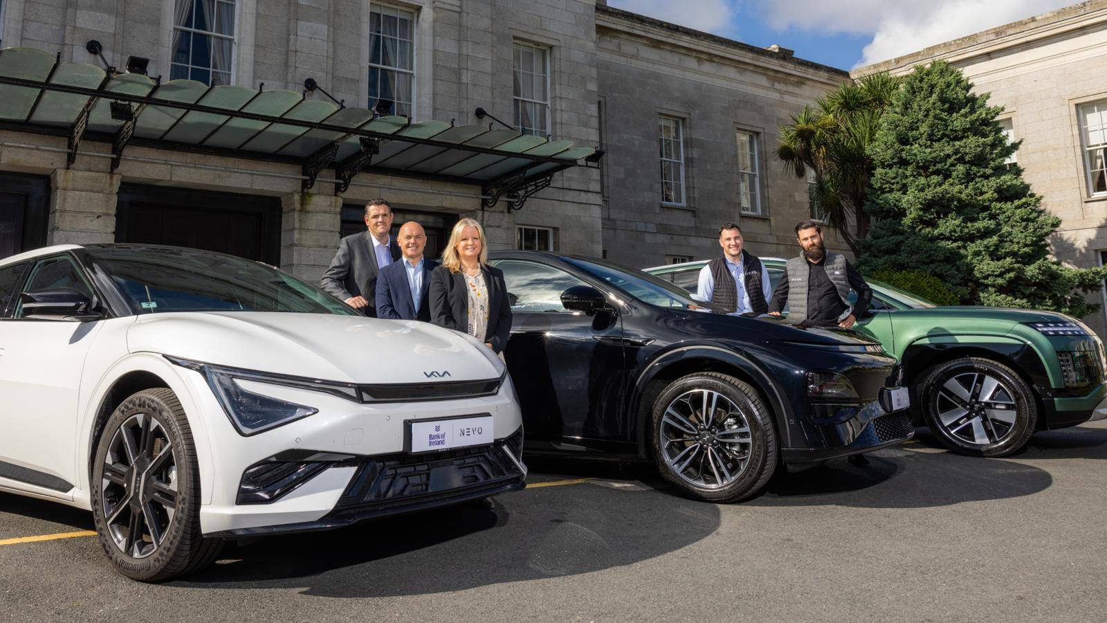 nevo and bank of ireland staff standing beside cars