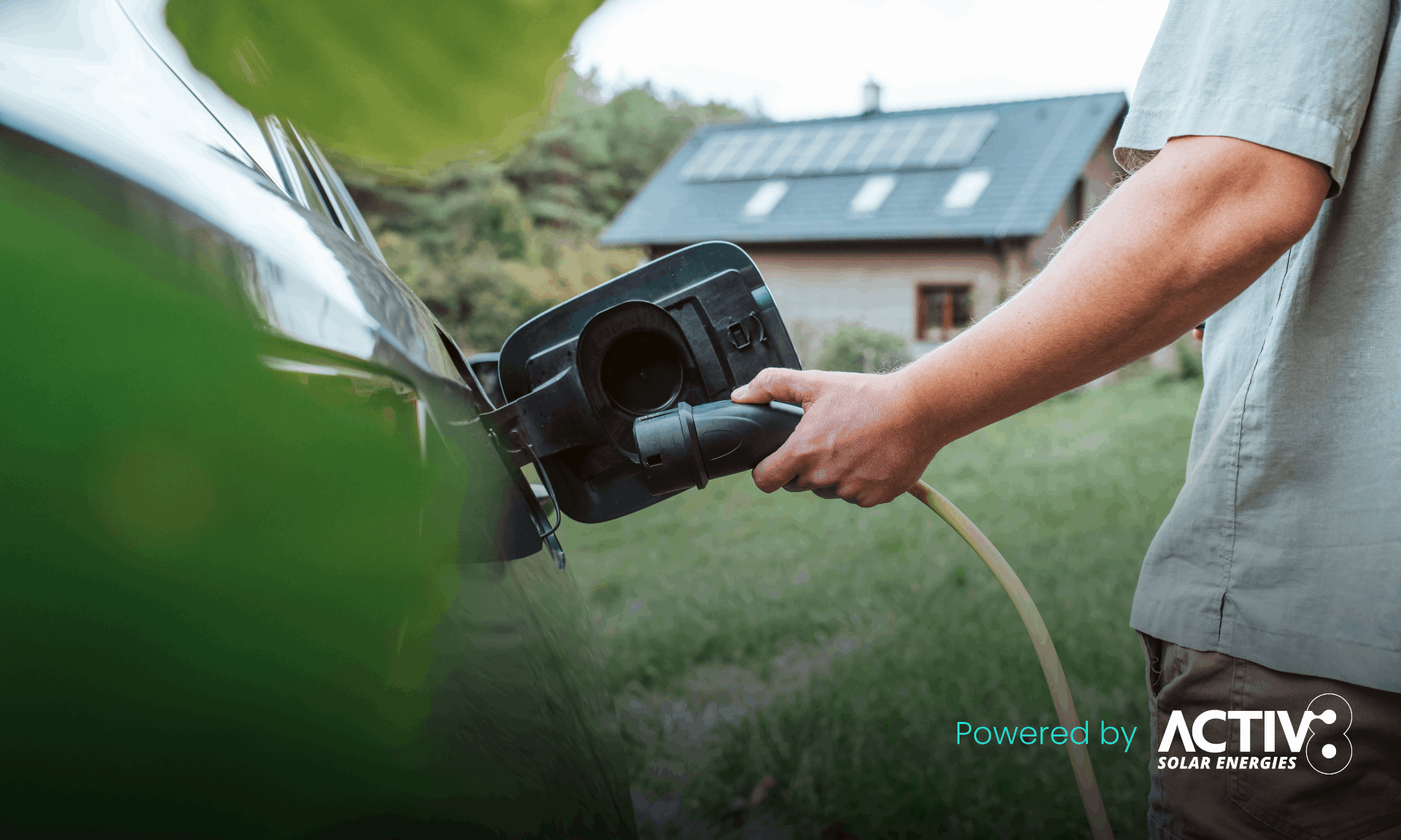 plugging electric car in with house in the background