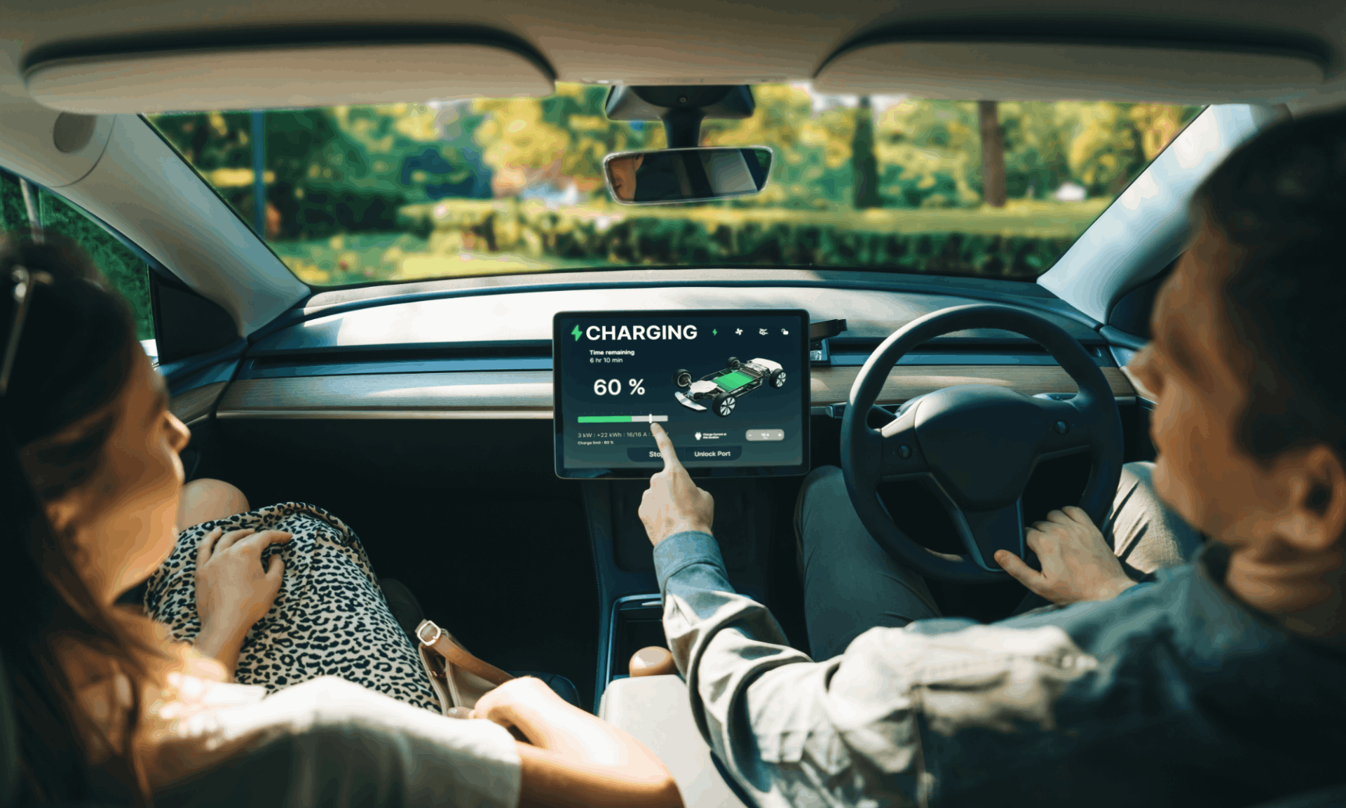 two people sitting in an electric car charging