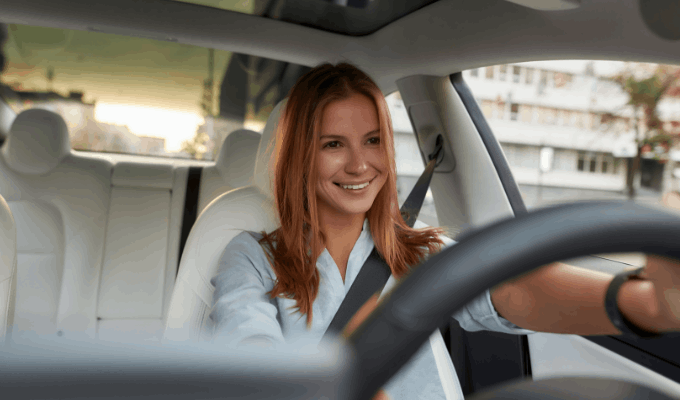red haired woman driving a car